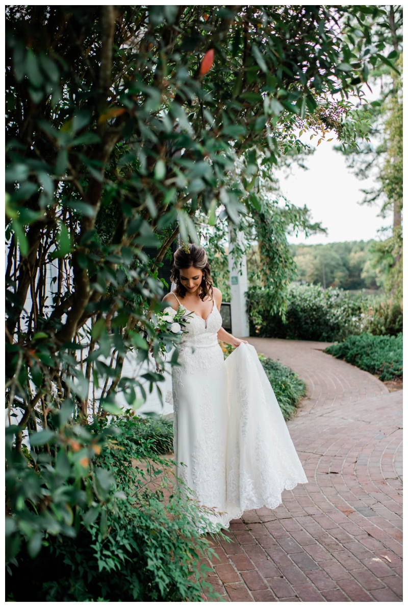Bride stands among lush greenery at The Tides Inn in Irvington, Virginia.