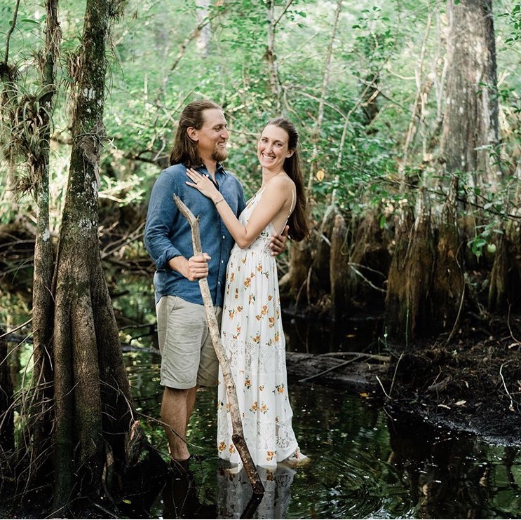 Newly engaged couple smiles and embraces in a swamp in Fort Myers, Florida.