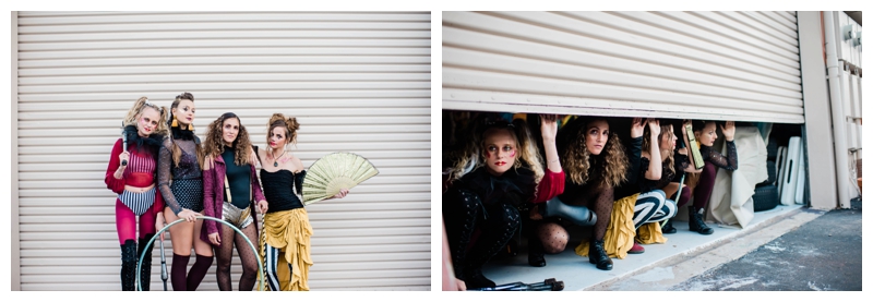 Group of female circus performers pose mischievously in urban garage setting.