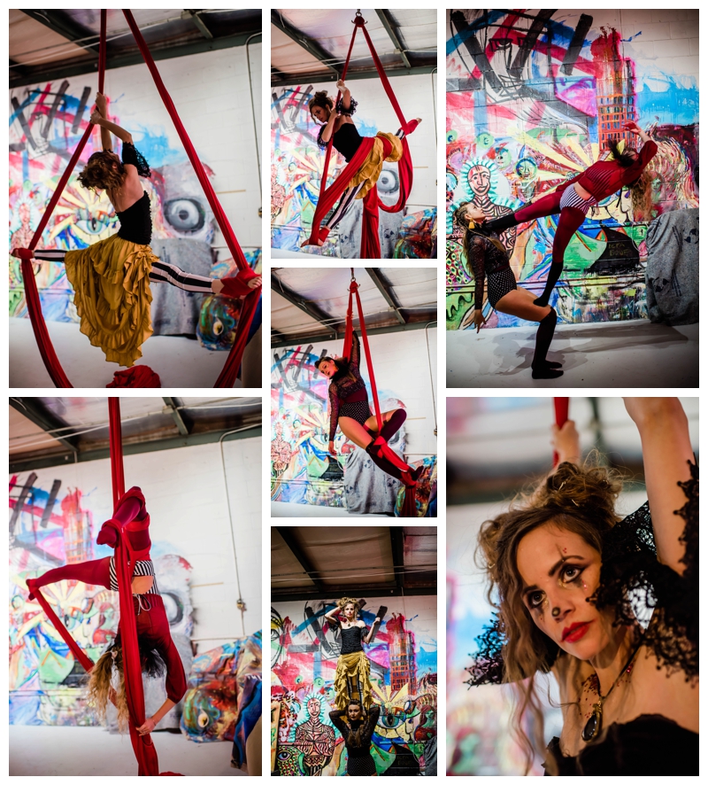 Female circus performers perform on hanging silks with graffiti backdrop.