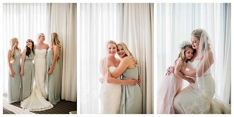 Bride embraces bridesmaids in light sage green bridesmaids dresses on Florida wedding day