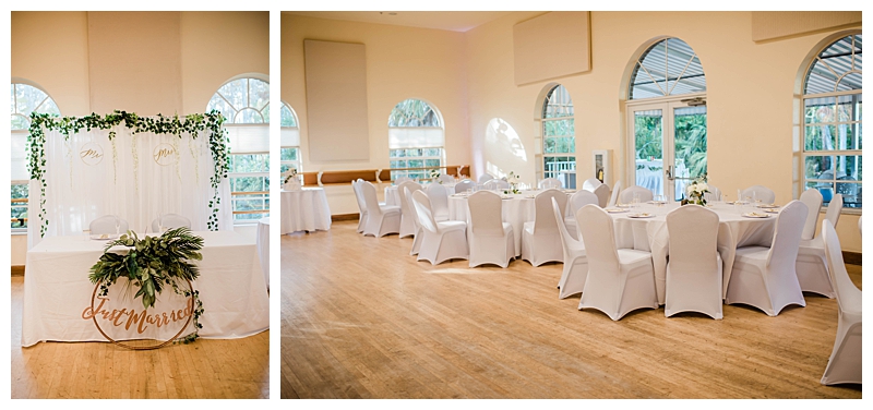 Wedding reception setting with white chair covers and white linen tables with draped greenery as decor.