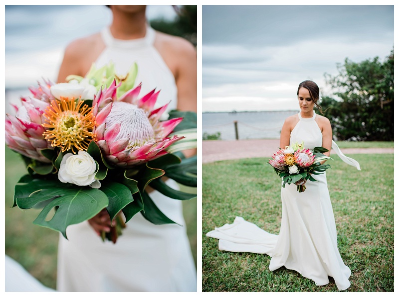 Tropical bride with classic sheath gown and low bridal bun with white orchid