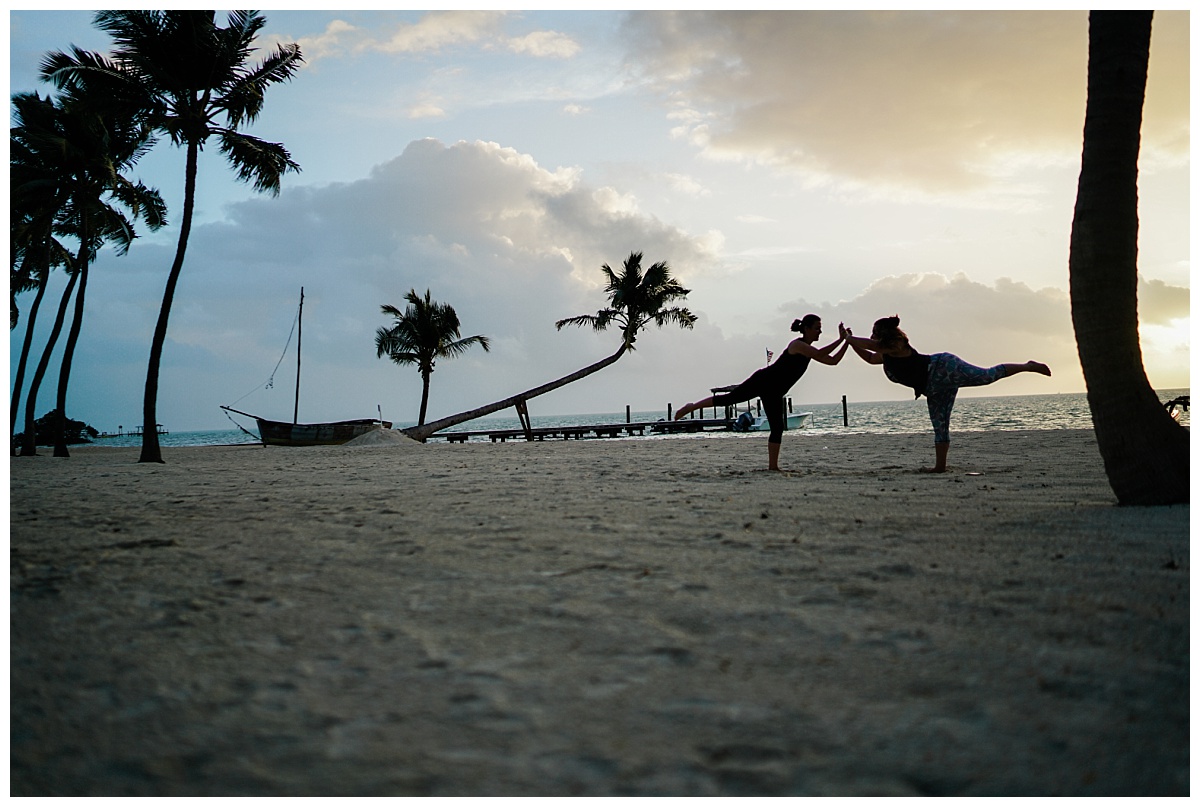 Two Fort Myers wedding photographers do yoga during sunrise