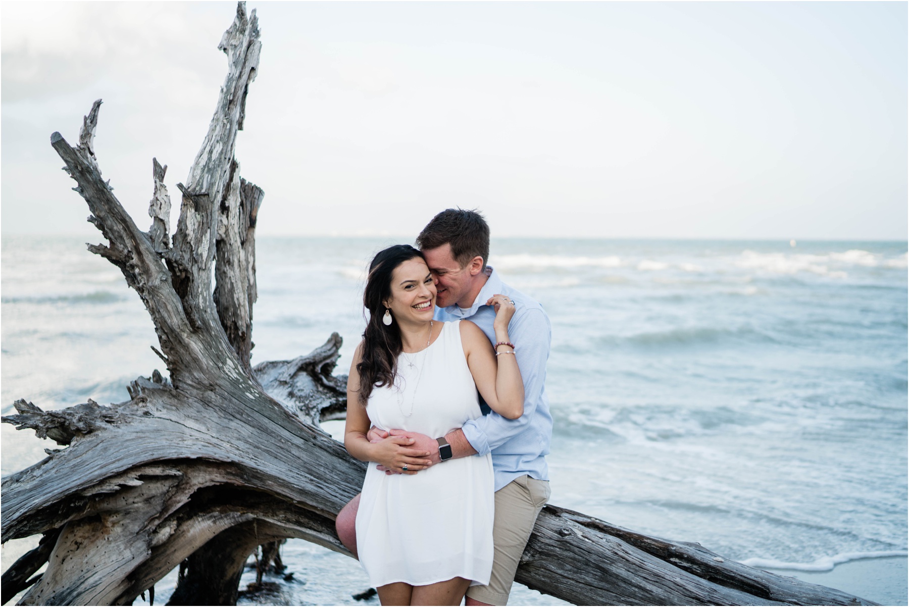 Couple laughs as they embrace on Sanibel Island beach during engagement session.