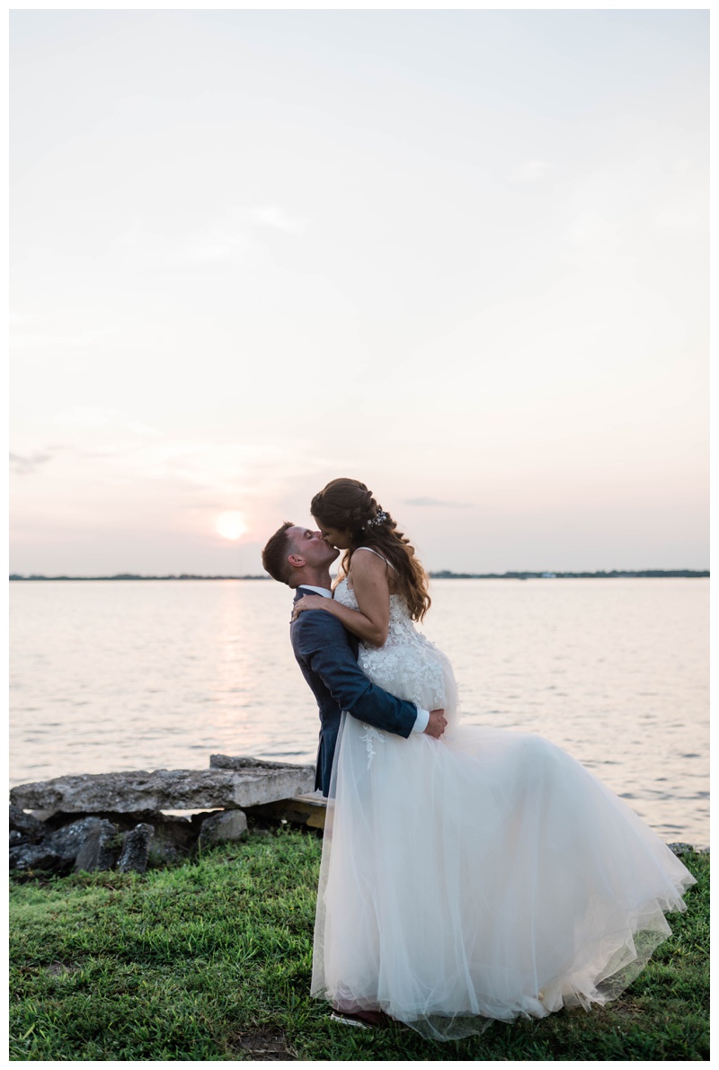 bride and groom kiss riverside on fort myers wedding day