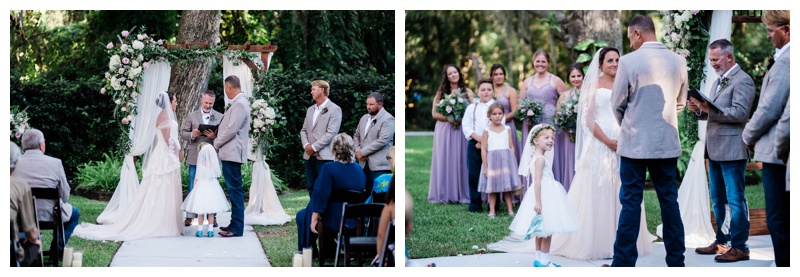 Bride and groom stand at draped arch during Southwest Florida wedding ceremony with their daughter the flower girl