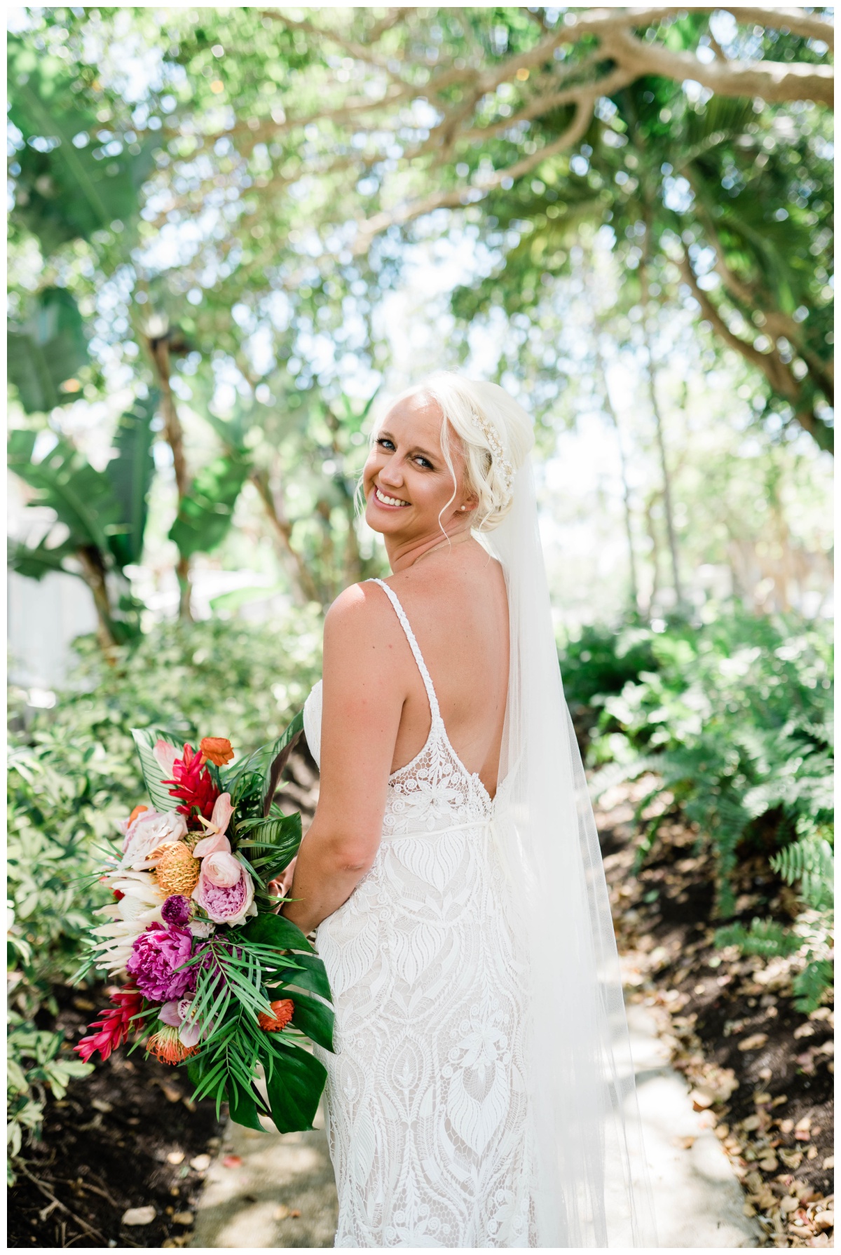 tropical beach bride with low back bridal gown and tropical bouquet on Southwest Florida destination wedding day