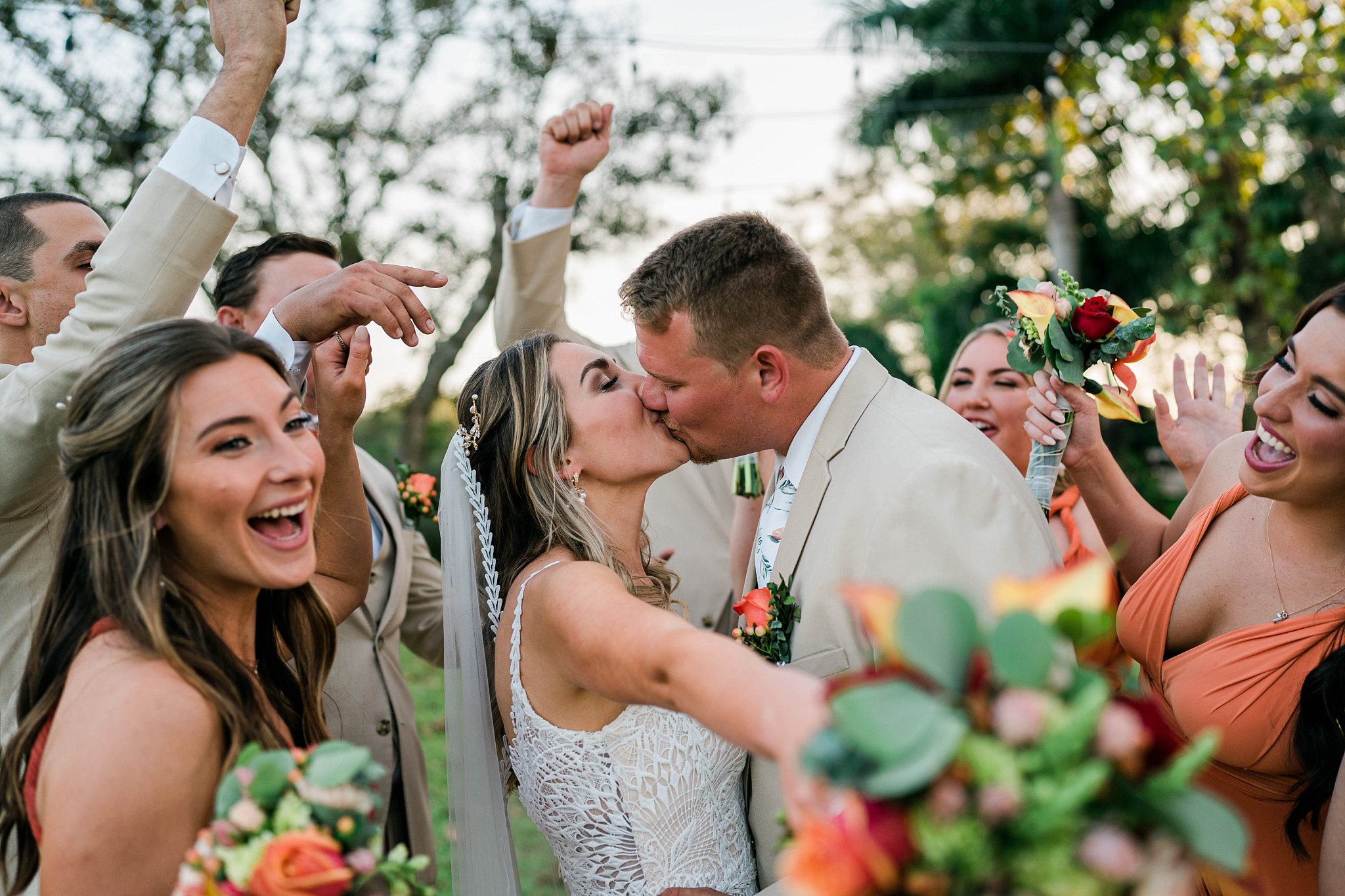 Bridal party celebrates as couple kisses during destination wedding in Southwest Florida