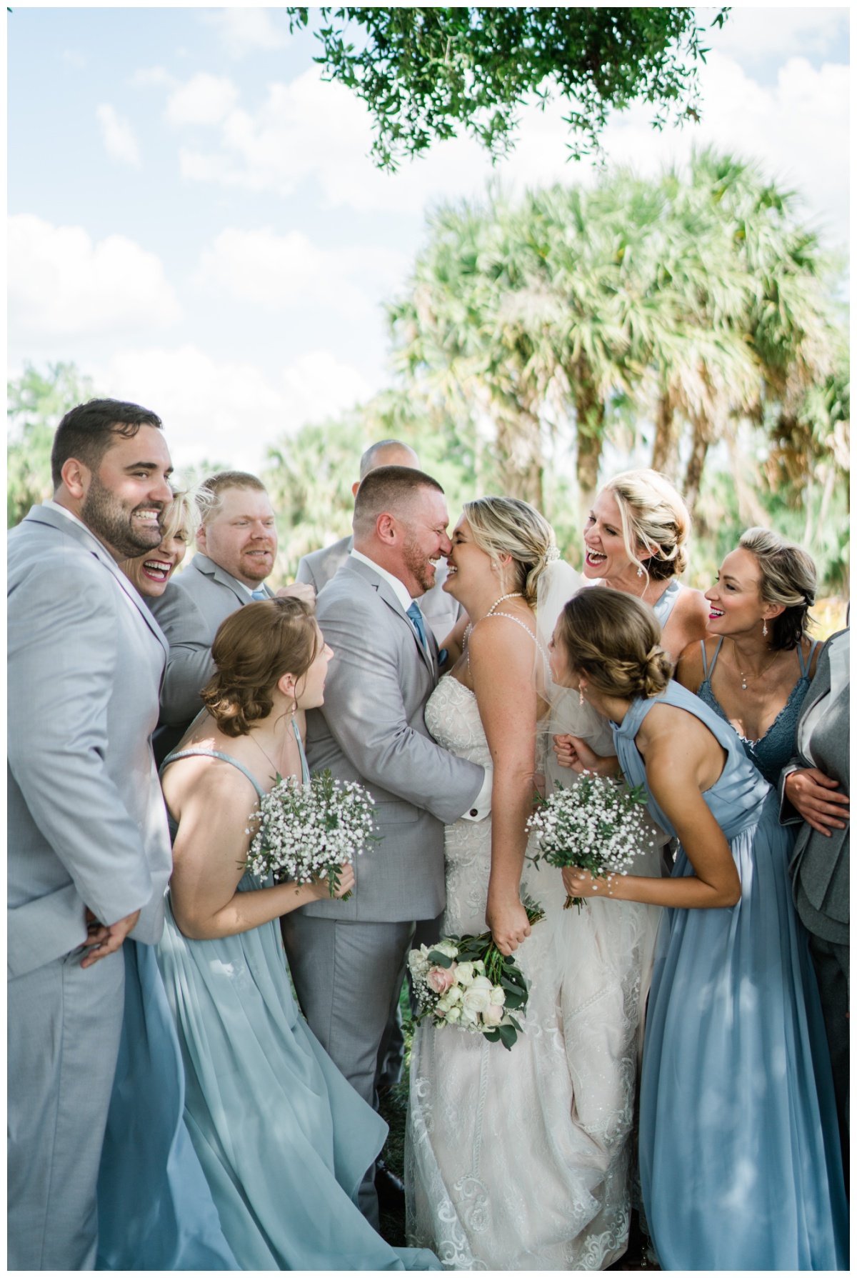 Bride and groom laugh with bridal party during White Rose Naples wedding day