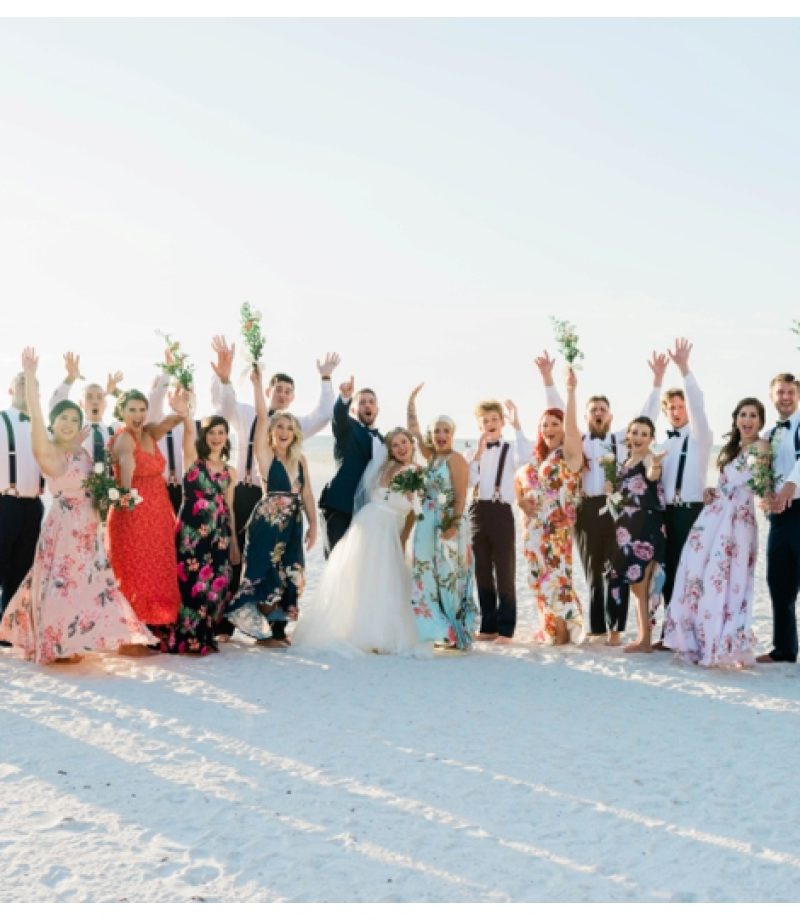 Large group of bride, bridesmaids and bridal party celebrate excitedly on Marco Island Beach.